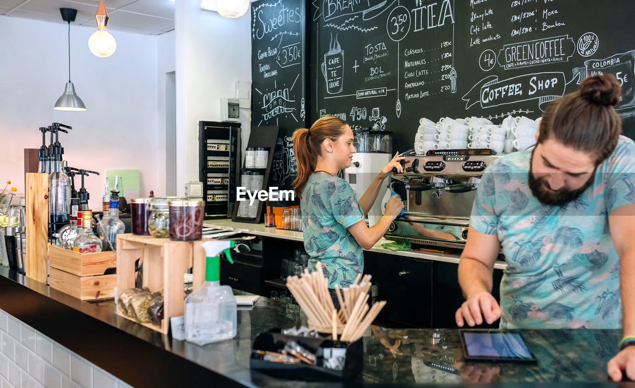 WOMAN STANDING IN FRONT OF PEOPLE AT CAFE