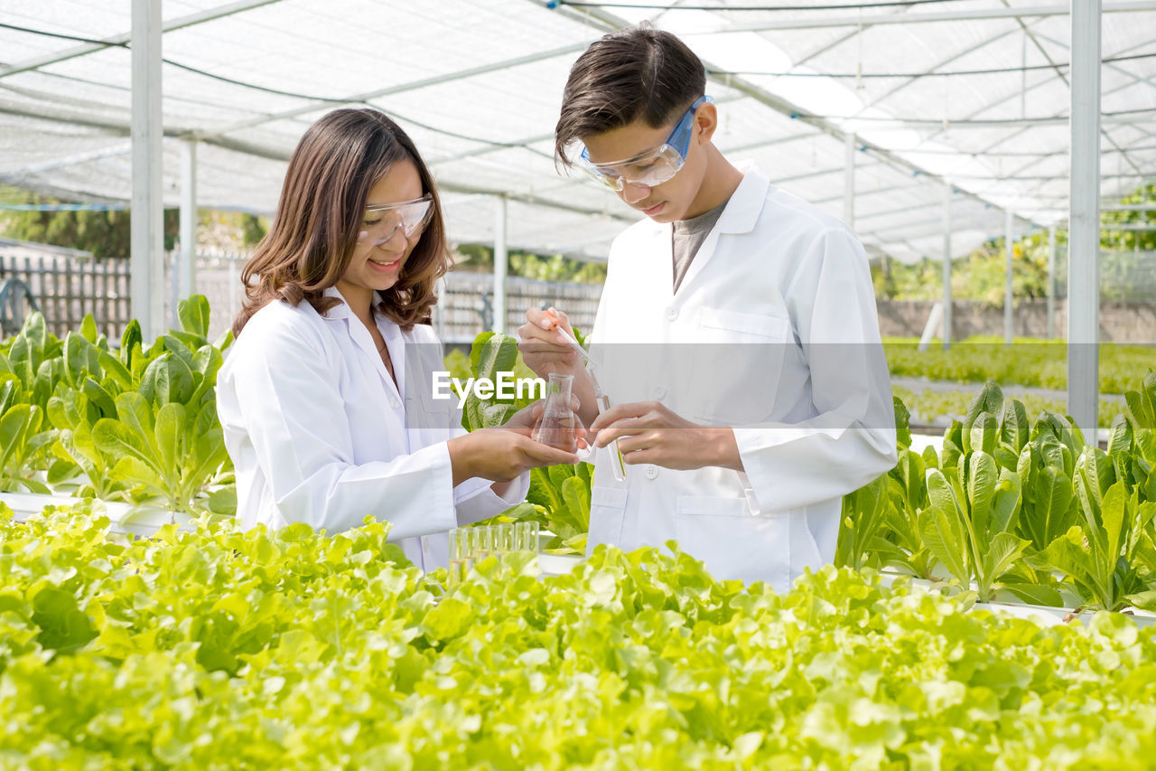 female doctor explaining to friend in greenhouse