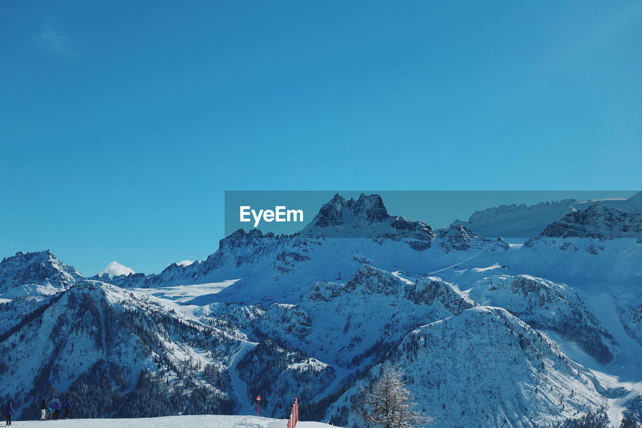 Scenic view of snowcapped mountains against clear blue sky