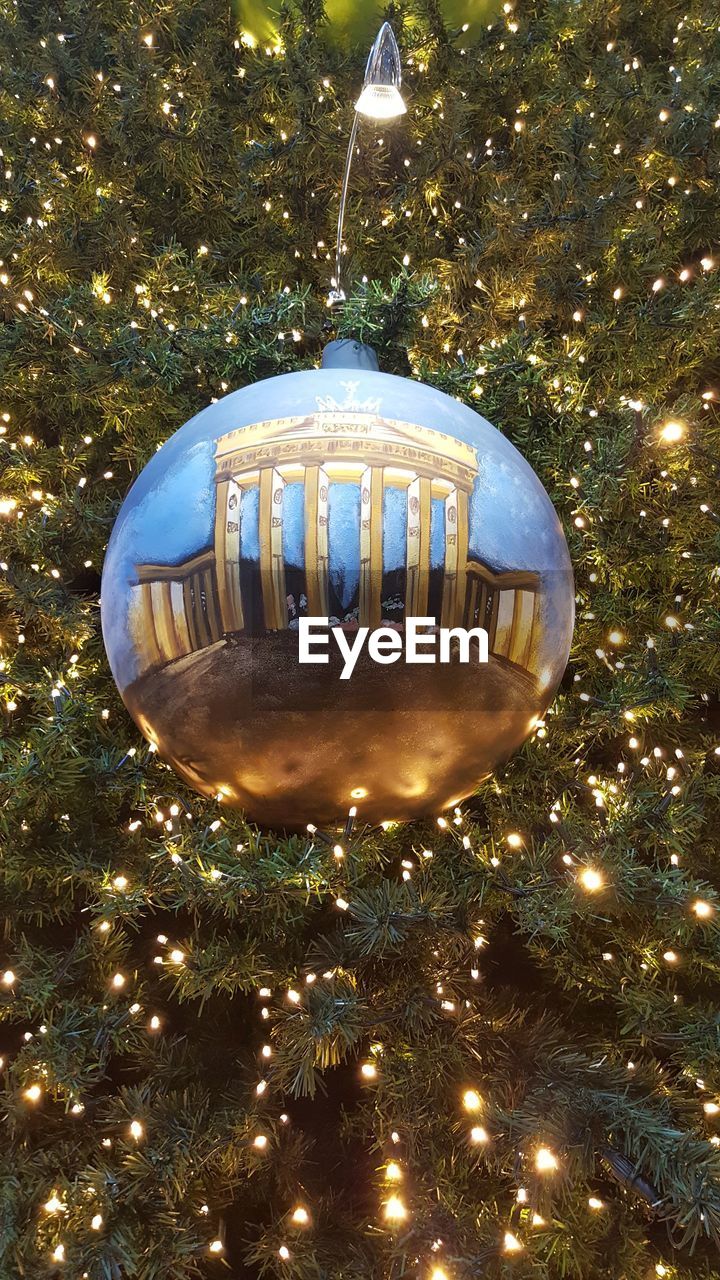 Close-up of ornament hanging on illuminated christmas tree