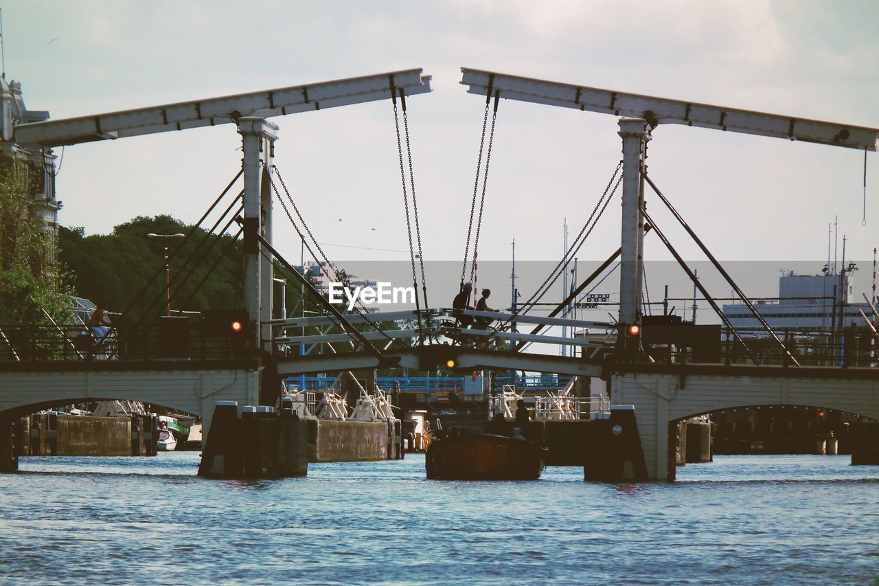 Low angle view of bridge over river against sky