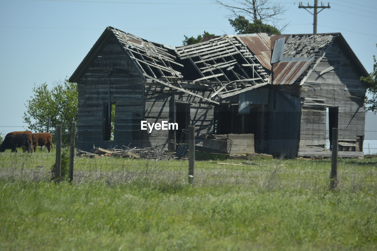 Abandoned house on field against sky