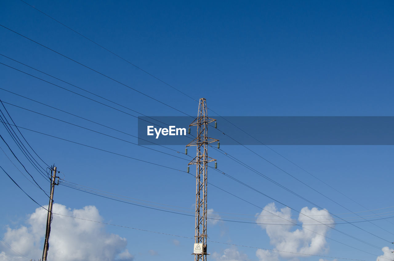 LOW ANGLE VIEW OF ELECTRICITY PYLONS AGAINST CLEAR BLUE SKY