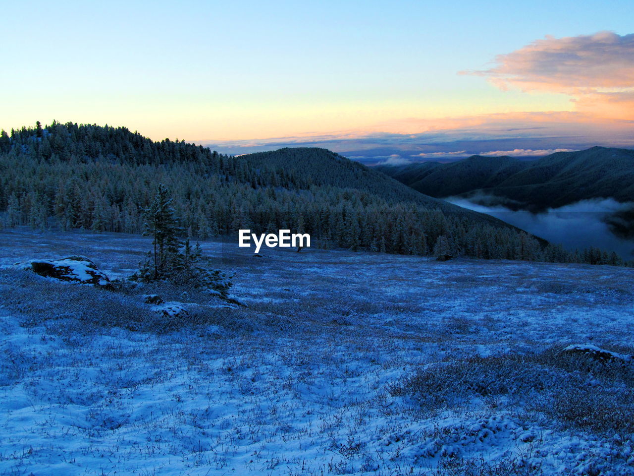 SCENIC VIEW OF SNOWCAPPED MOUNTAINS DURING SUNSET