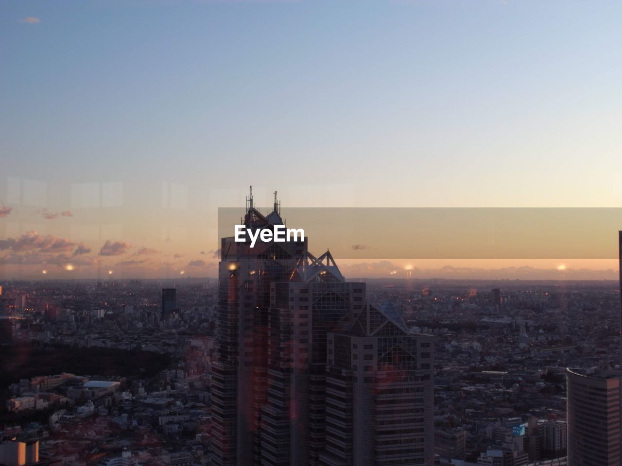 Buildings in city against sky during sunset