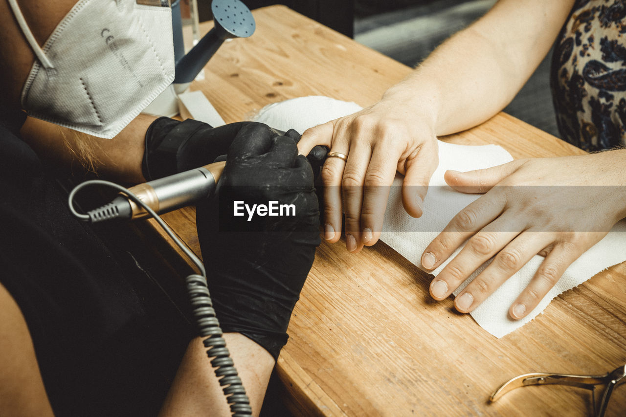 Beautician working with mask and protective screen for the virus covid