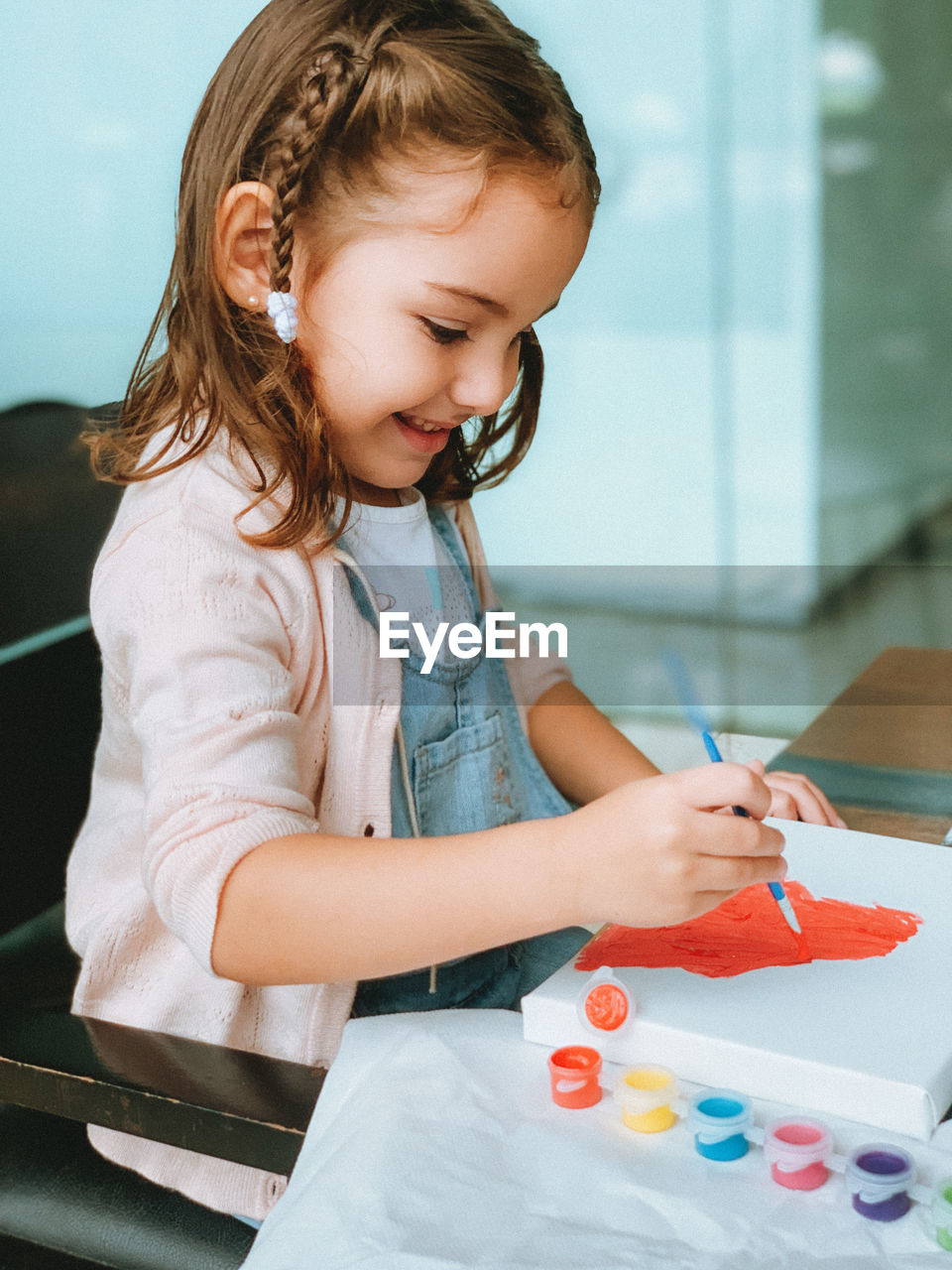 Portrait of cute girl holding painting