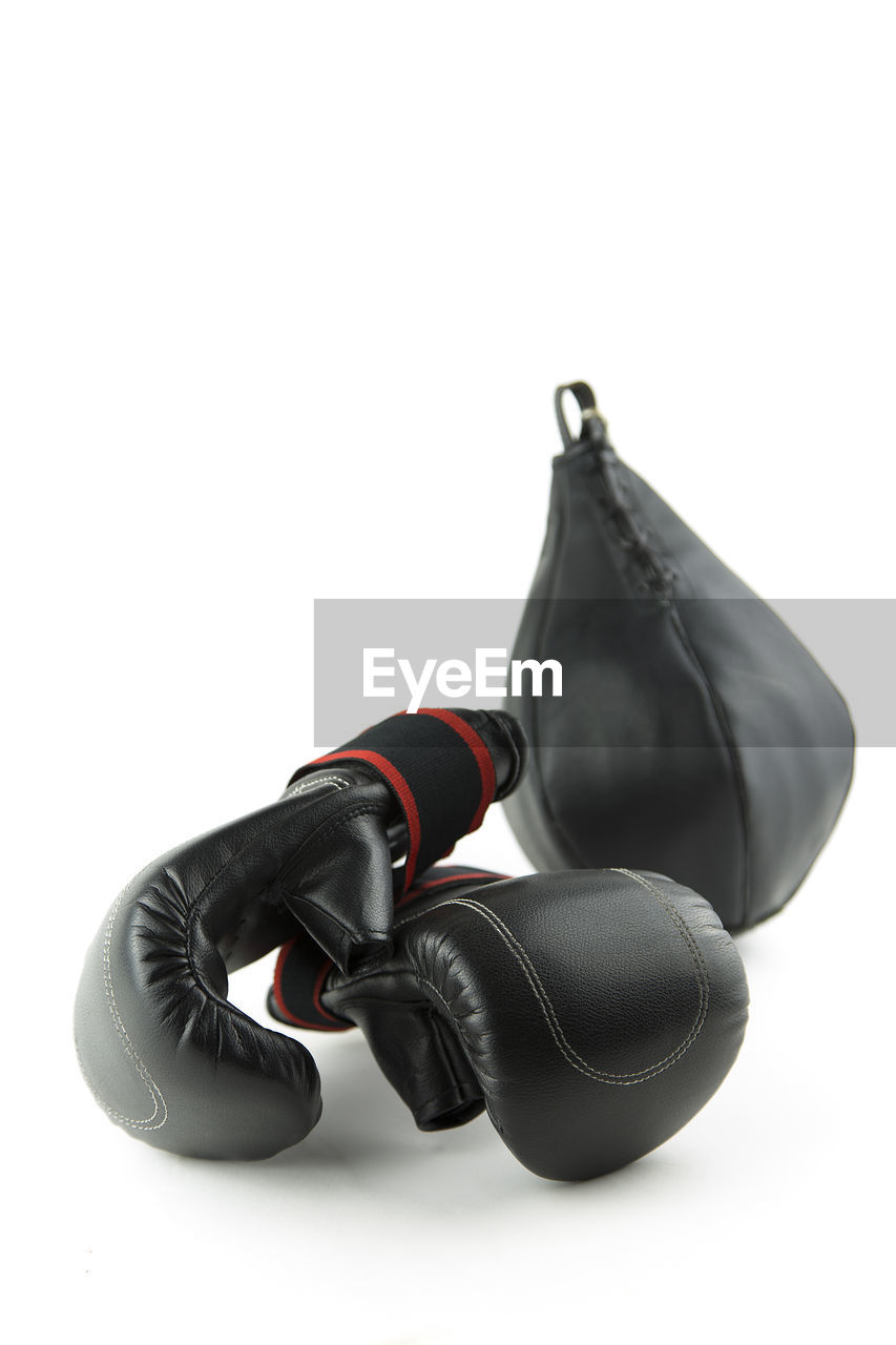Boxing gloves and punching bag against white background