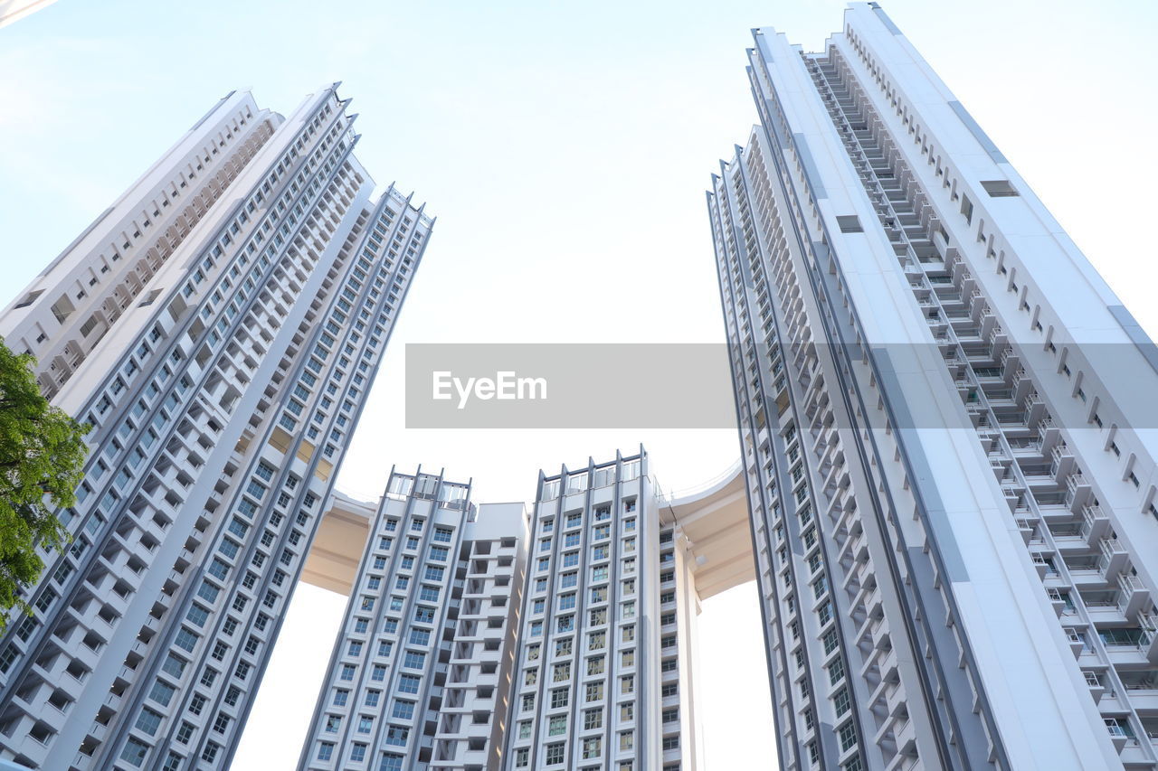 Low angle view of modern high rising buildings with sky bridge link up.