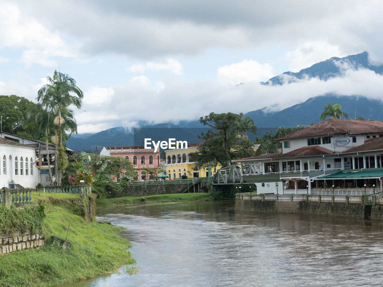 BUILDINGS BY RIVER AGAINST SKY