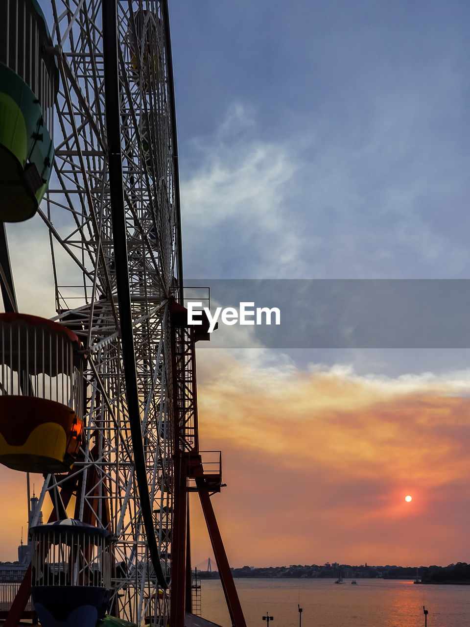 LOW ANGLE VIEW OF FERRIS WHEEL IN SEA AGAINST SKY