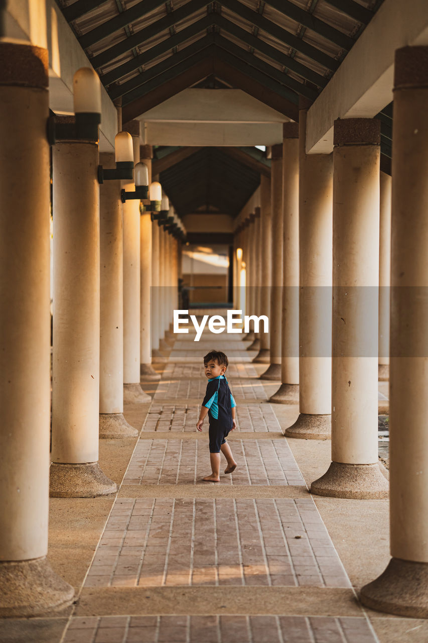 Full length of boy walking in corridor of building