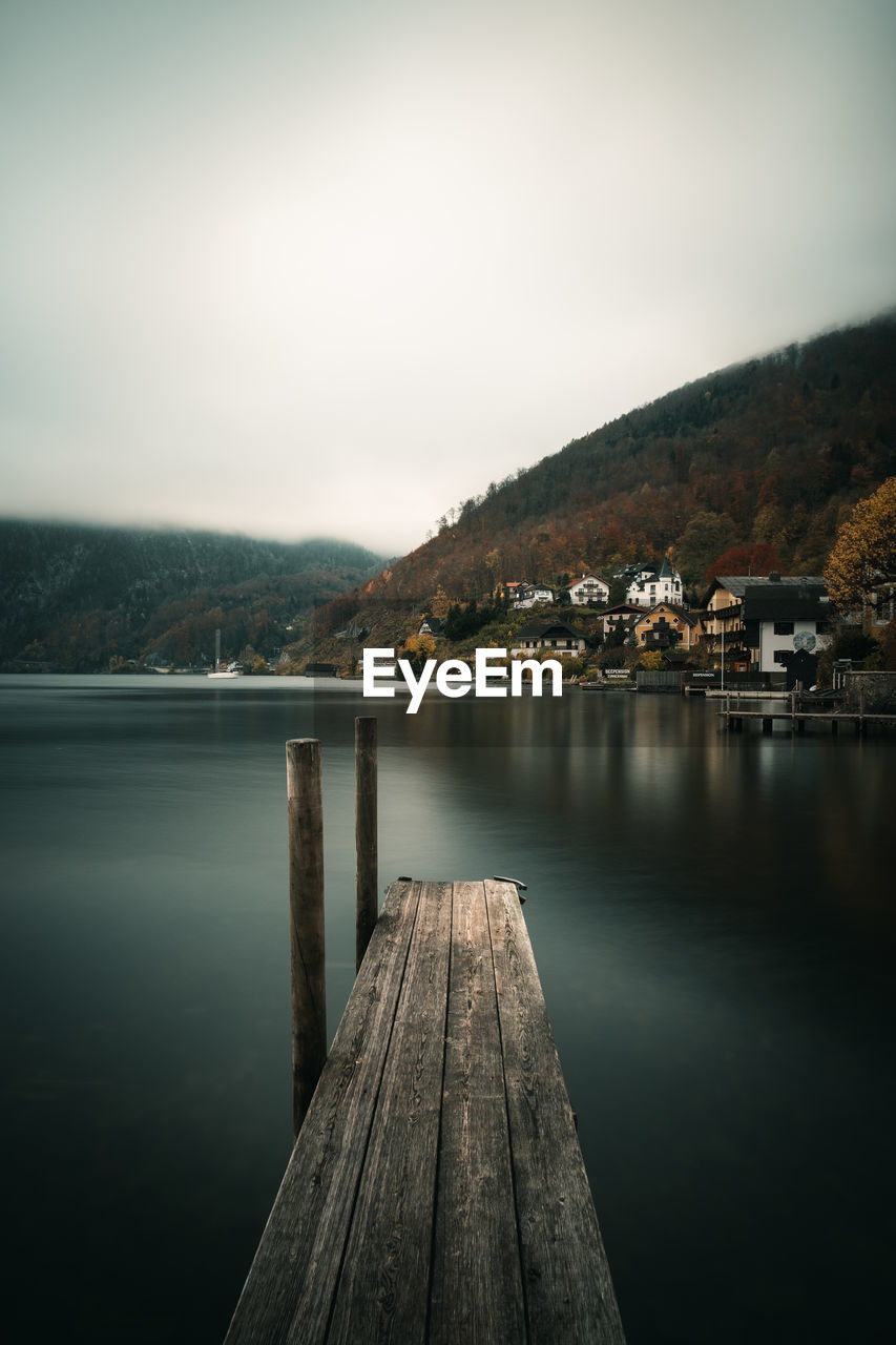 WOODEN POSTS IN LAKE AGAINST SKY