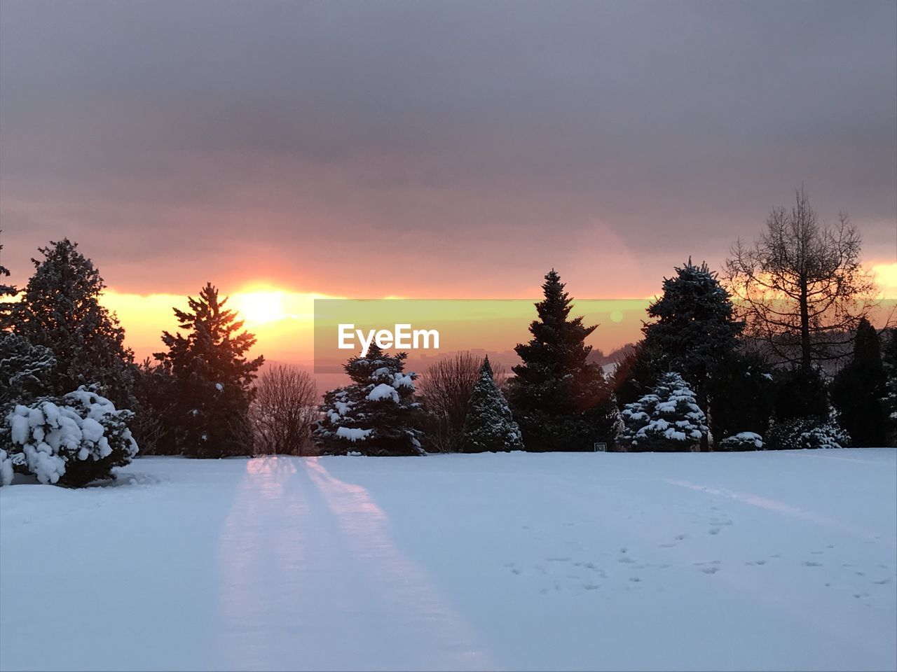 SCENIC VIEW OF SNOW COVERED LANDSCAPE AGAINST SKY AT SUNSET