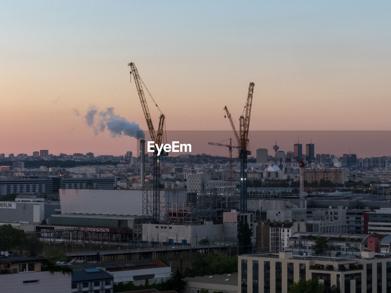 Buildings in city against sky during sunset
