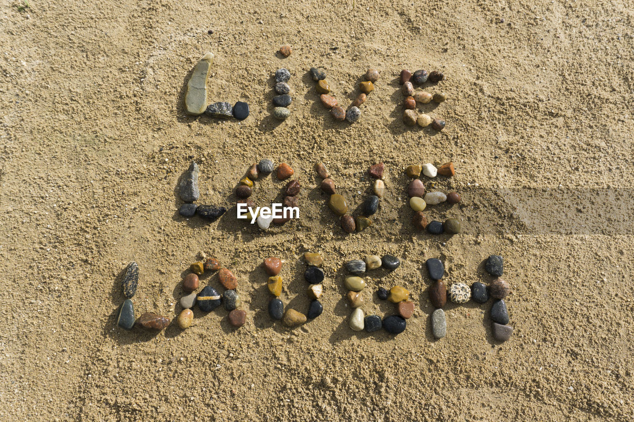 HIGH ANGLE VIEW OF TEXT ON BEACH