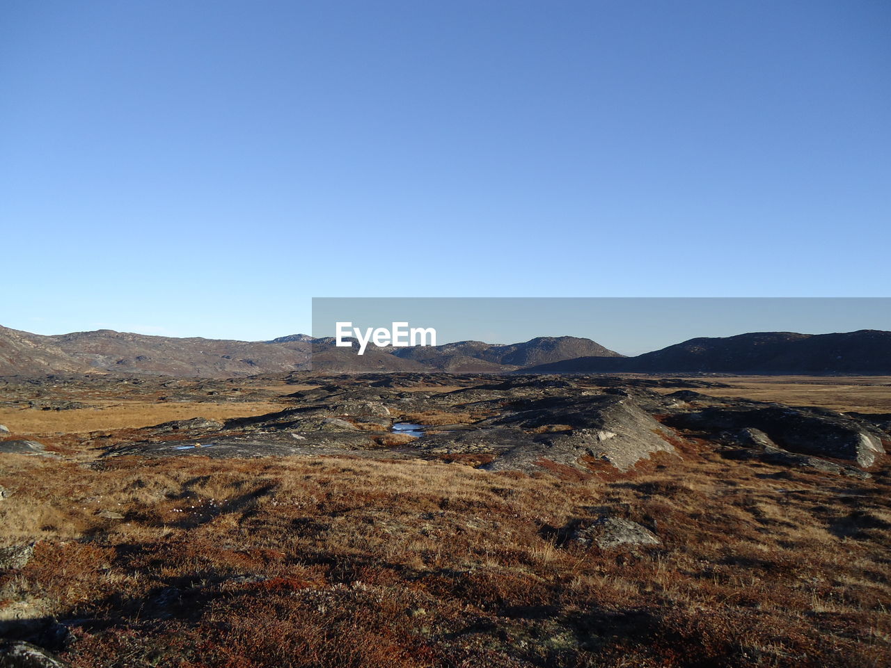 Scenic view of desert against clear blue sky