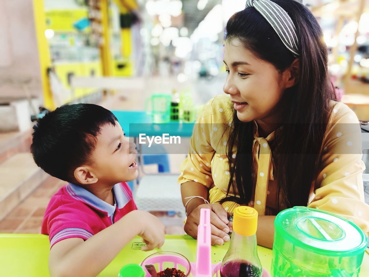 Close-up of smiling mother and son sitting at restaurant