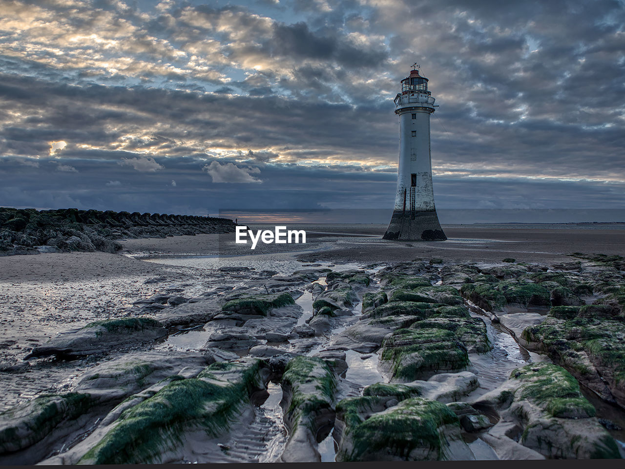 Lighthouse in sea against sky