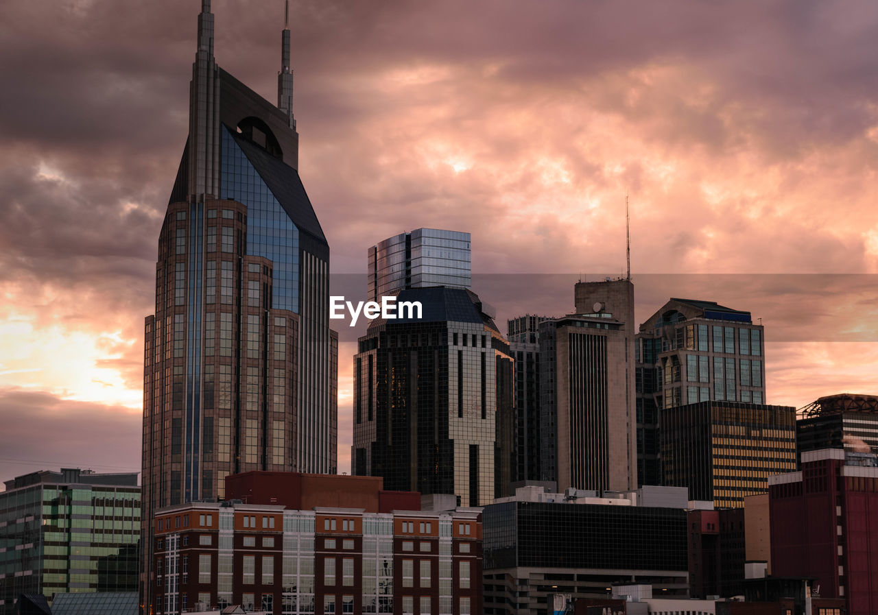 Low angle view of skyscrapers against sky during sunset