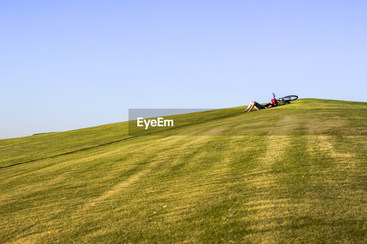 Man on golf course on field against clear sky