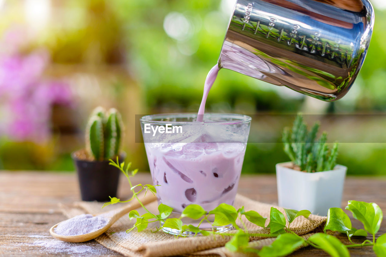 CLOSE-UP OF DRINK ON TABLE AGAINST BLURRED BACKGROUND