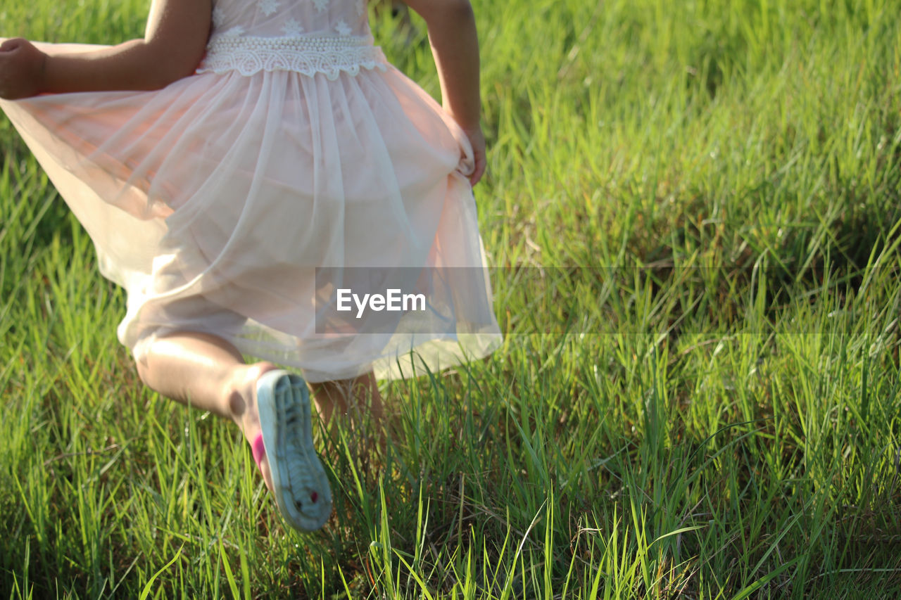 Low section of girl running on grass 