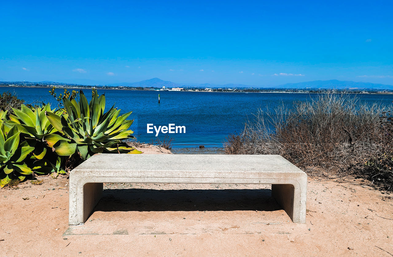 water, sea, nature, beach, land, shore, sky, scenics - nature, vacation, plant, tranquility, beauty in nature, sand, ocean, tranquil scene, blue, no people, coast, travel destinations, horizon over water, sunlight, clear sky, body of water, tropical climate, sunny, day, holiday, outdoors, horizon, travel, trip, seat, tree, bay, relaxation, landscape, idyllic, grass, summer, tourism, furniture, coastline, environment, seascape, palm tree, wood