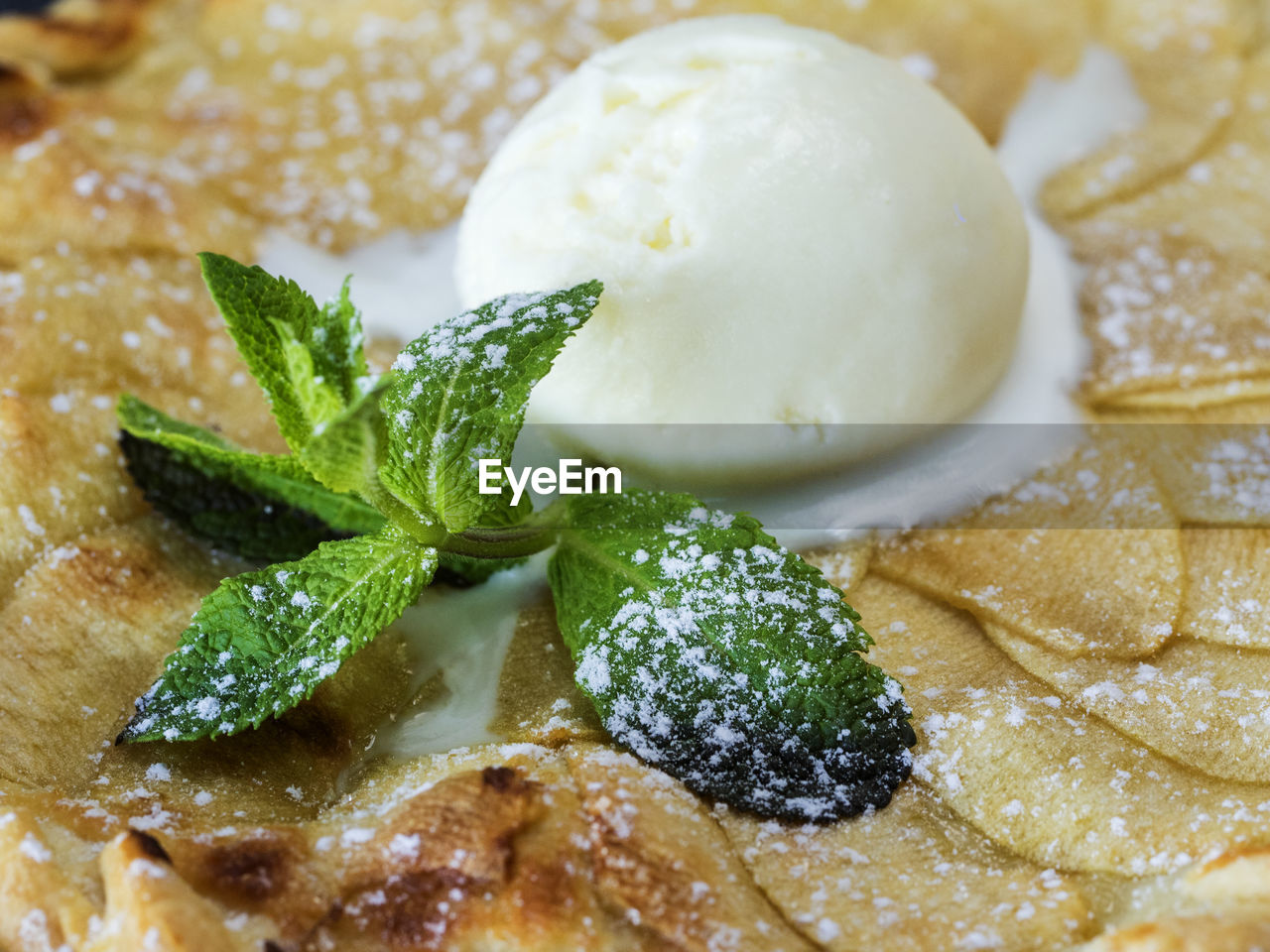 High angle close-up of apple tart with ice cream and mint
