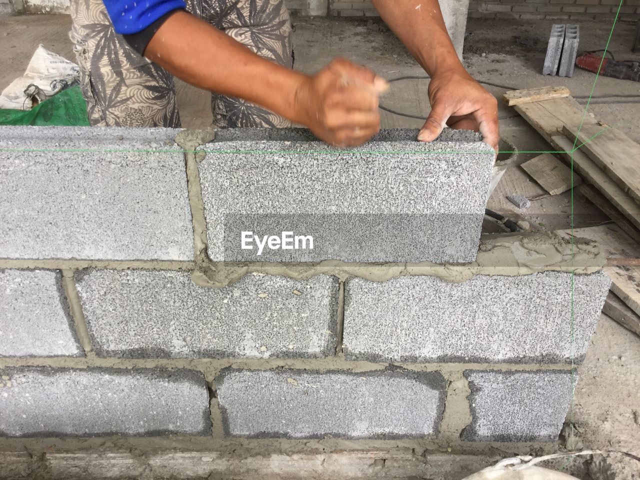 MIDSECTION OF MAN WORKING ON WALL