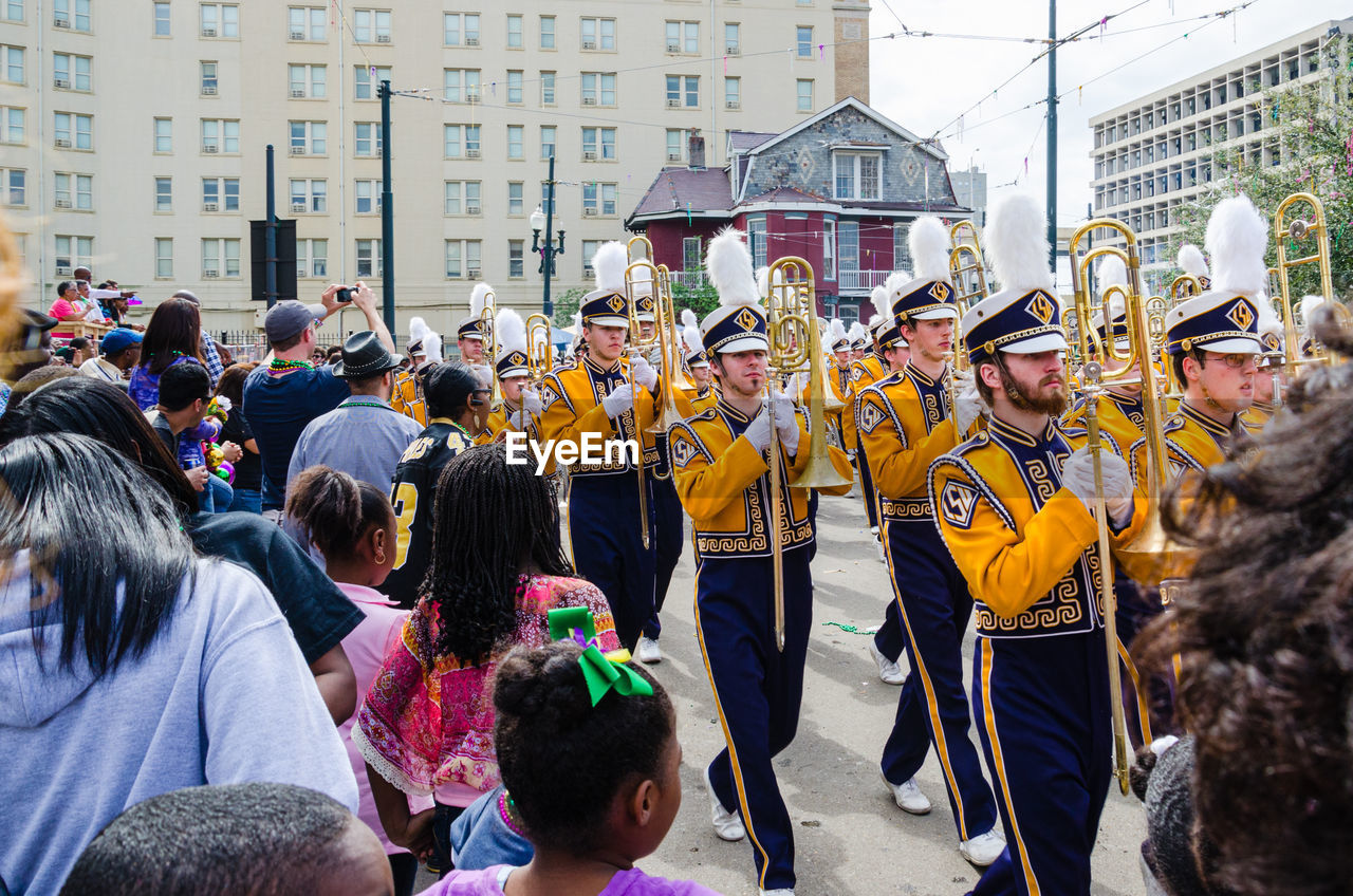 crowd, group of people, large group of people, city, architecture, street, celebration, arts culture and entertainment, event, men, building exterior, women, marching, adult, built structure, festival, togetherness, day, music, outdoors, carnival, performance, person, city life