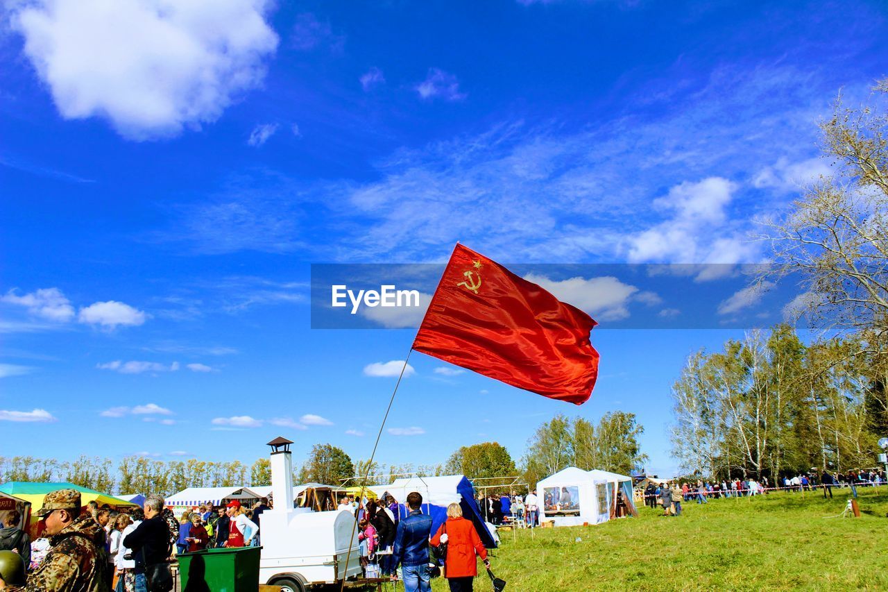 GROUP OF PEOPLE FLAG IN FLAGS AGAINST SKY