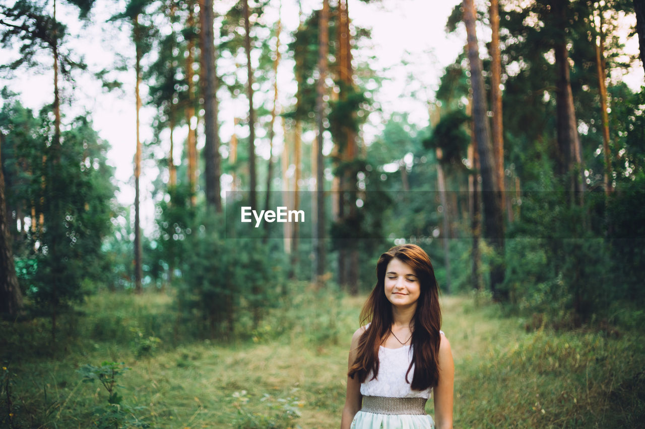 Smiling young woman in forest