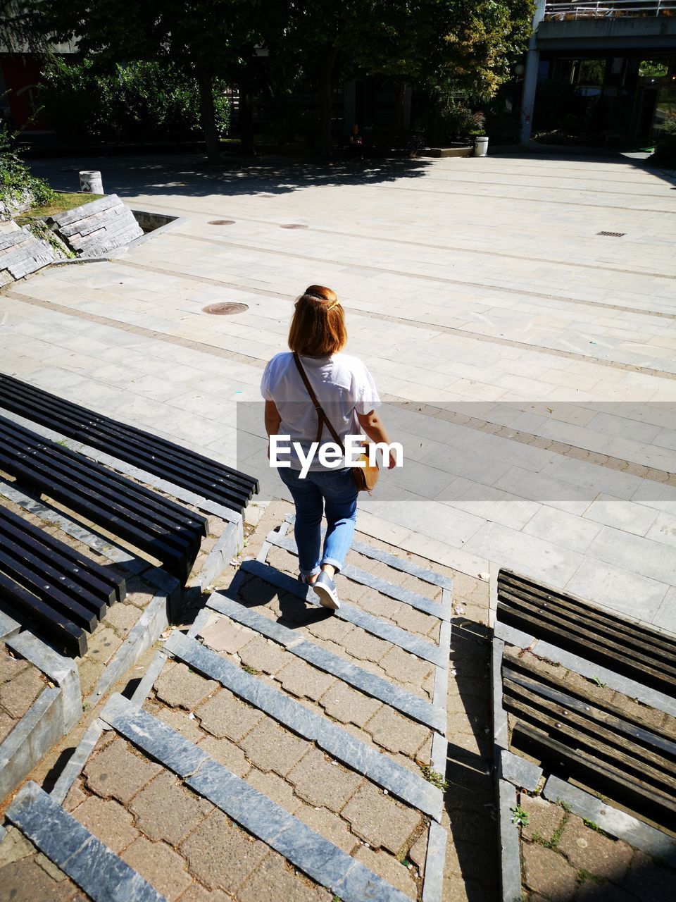 Rear view of woman walking on steps in city