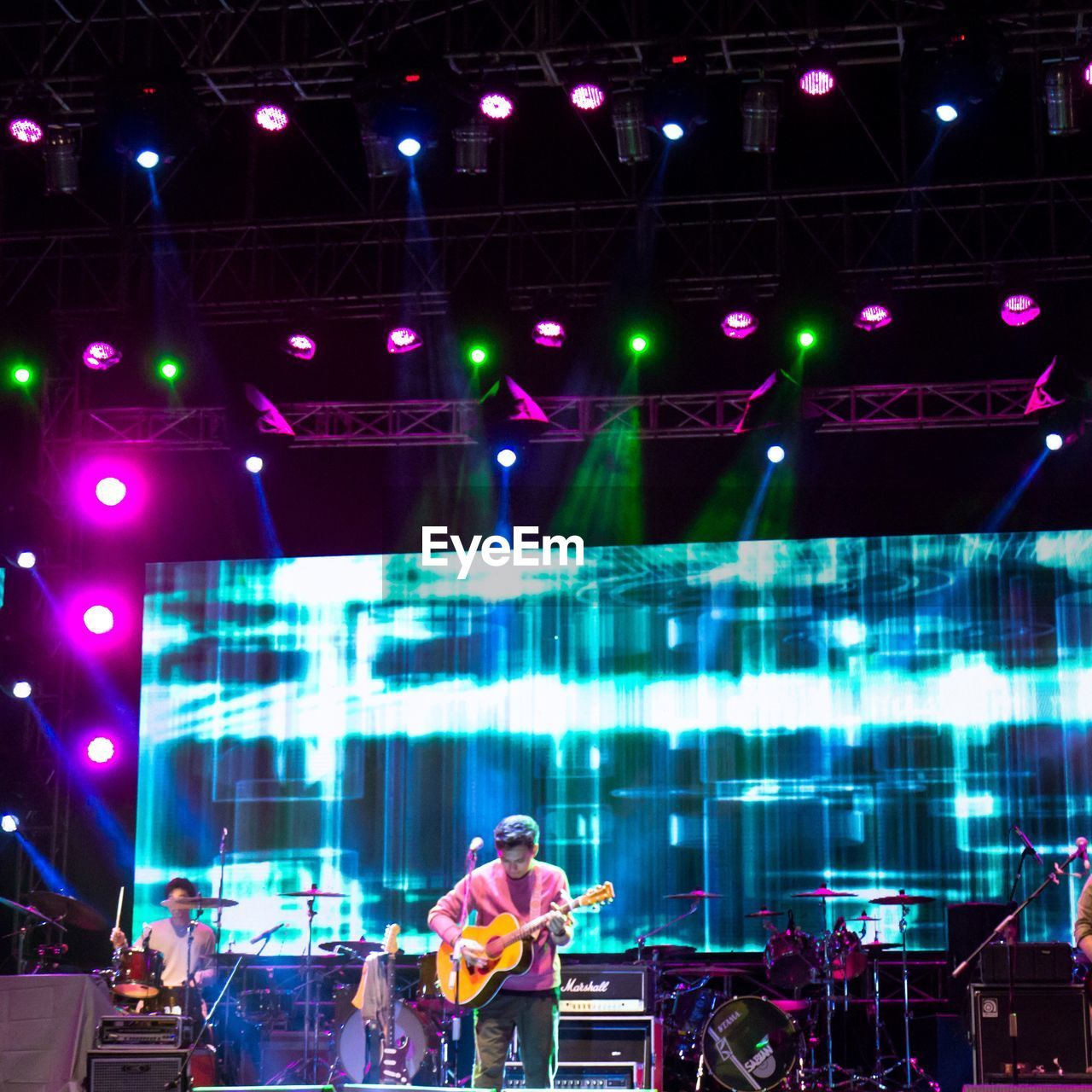 PEOPLE STANDING AT ILLUMINATED CONCERT