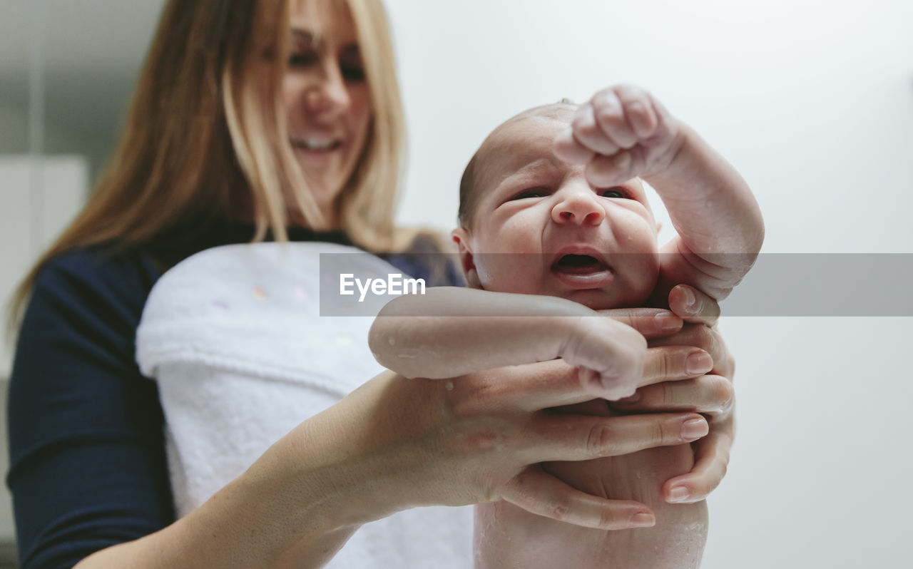 Mother holding wet son at bathroom