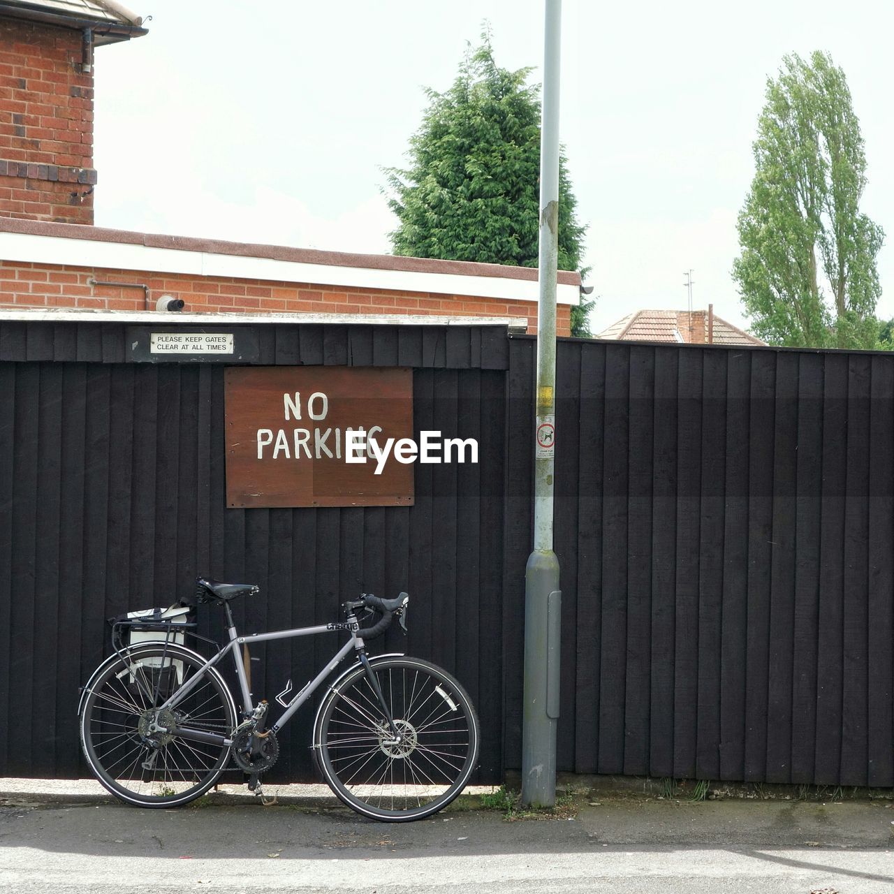 Bicycle parked against information sign on railing