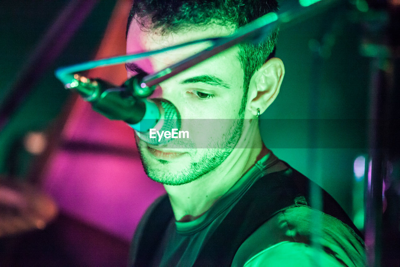 CLOSE-UP PORTRAIT OF YOUNG MAN WEARING MULTI COLORED MASK