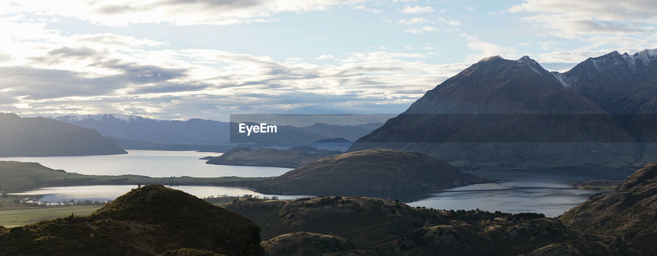 Scenic view of sea and mountains against sky