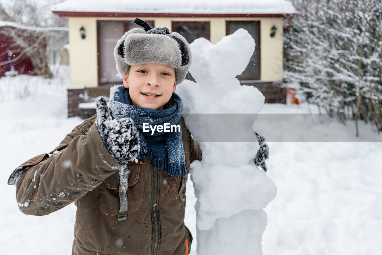 Portrait of boy with snowman