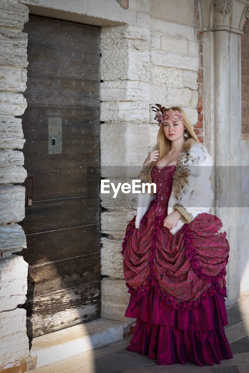 Full length of beautiful teenage girl wearing dress while standing by door