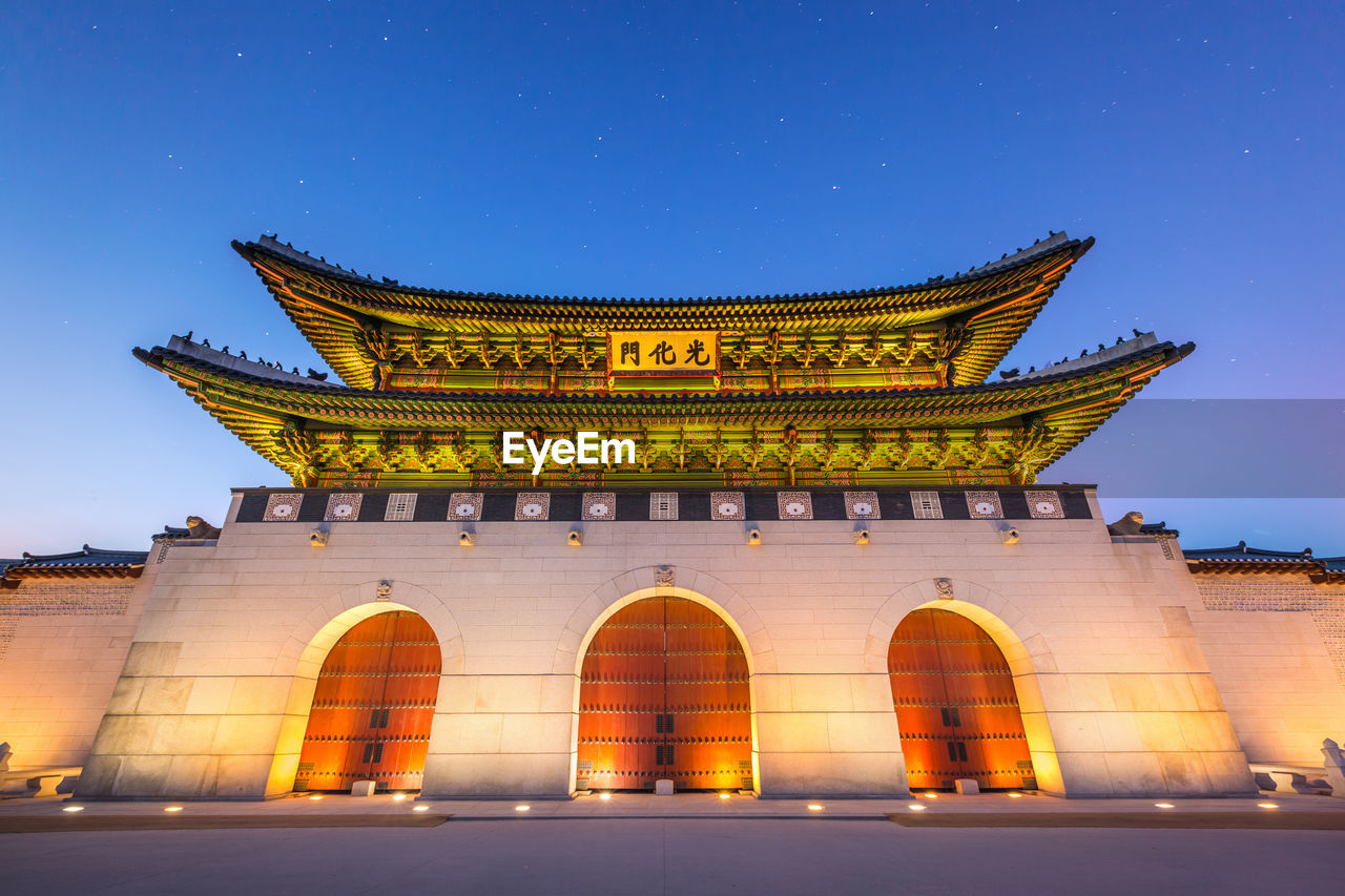 LOW ANGLE VIEW OF ILLUMINATED HISTORICAL BUILDING AGAINST BLUE SKY