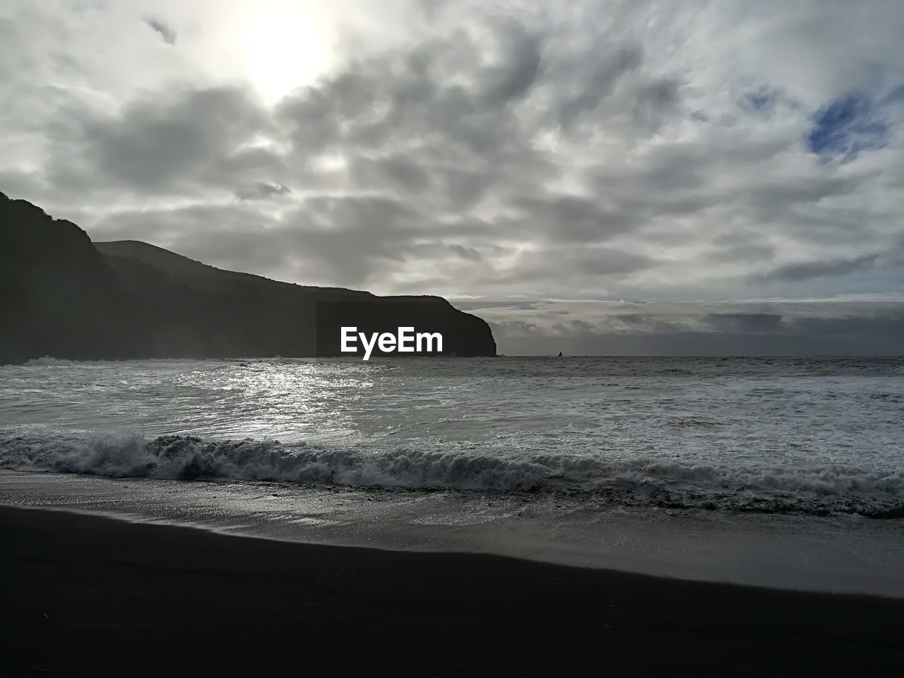 VIEW OF BEACH AGAINST CLOUDY SKY