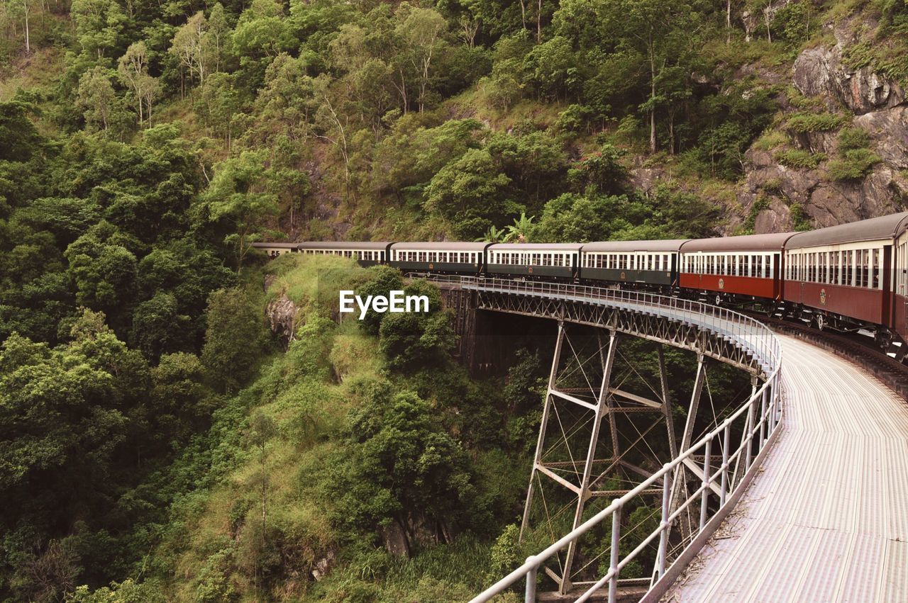 Train moving on railway bridge amidst mountains