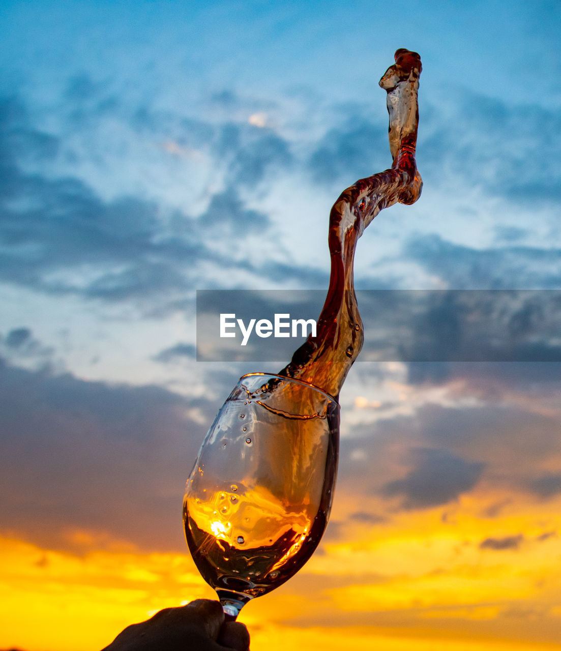 Close-up of frozen splash of wine against sky during sunset