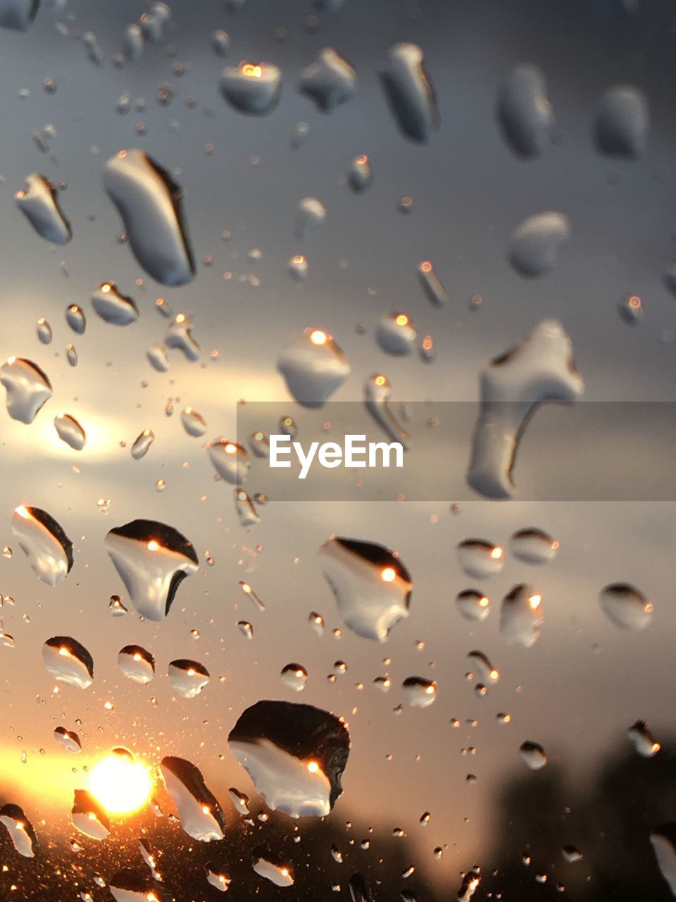 CLOSE-UP OF RAINDROPS ON GLASS WINDOW