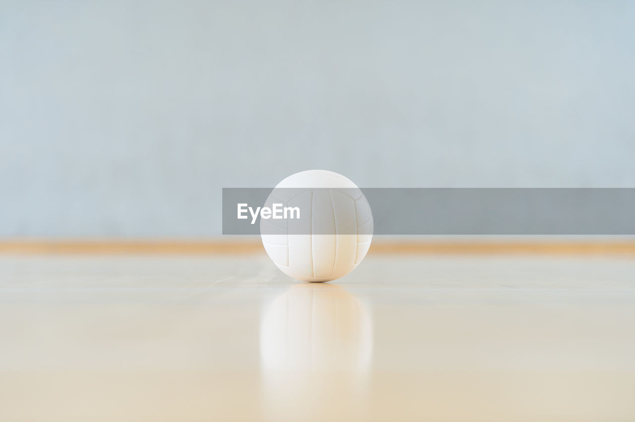 CLOSE-UP OF WHITE BALL ON TABLE AGAINST WALL