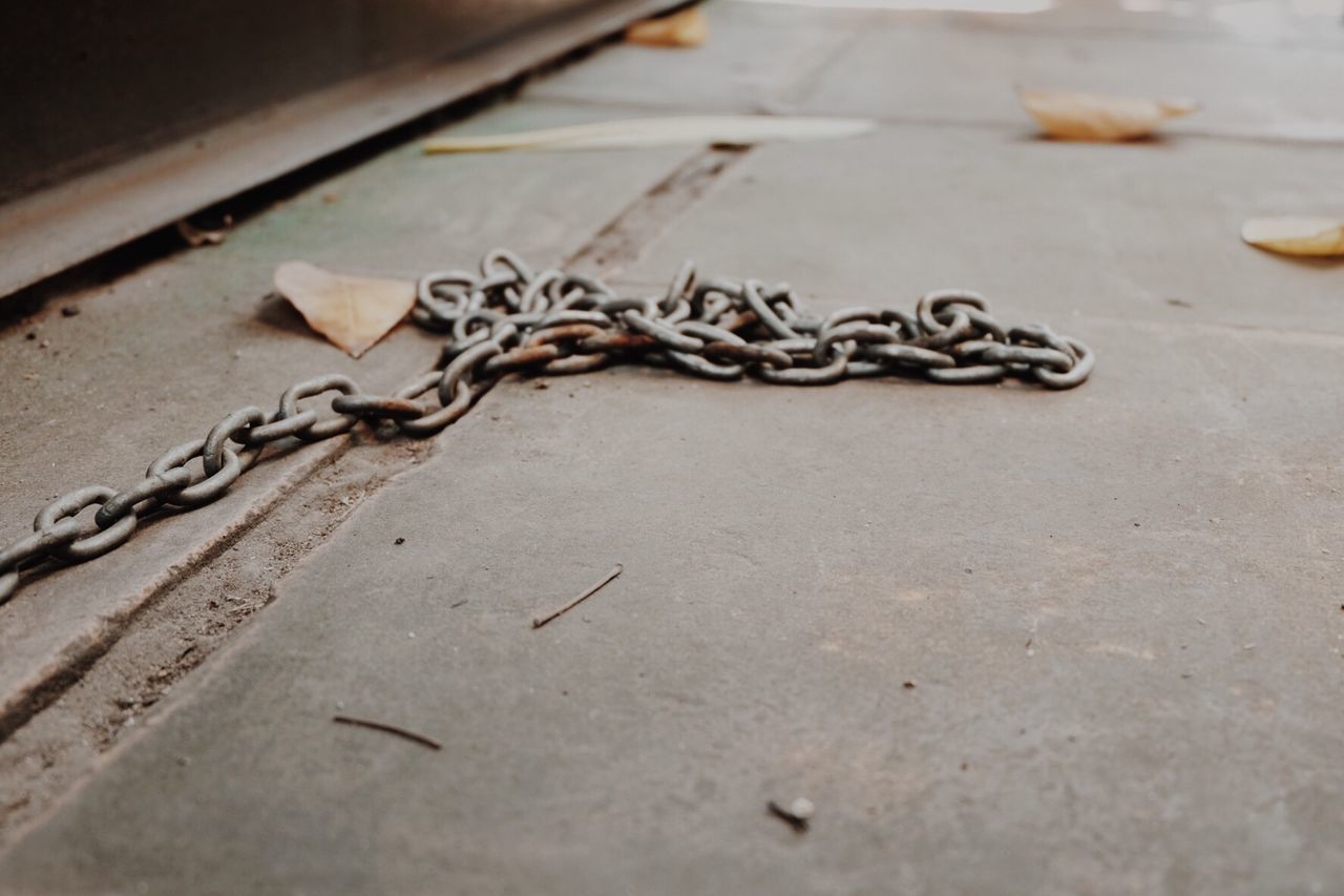CLOSE UP OF CHAIN ON GROUND
