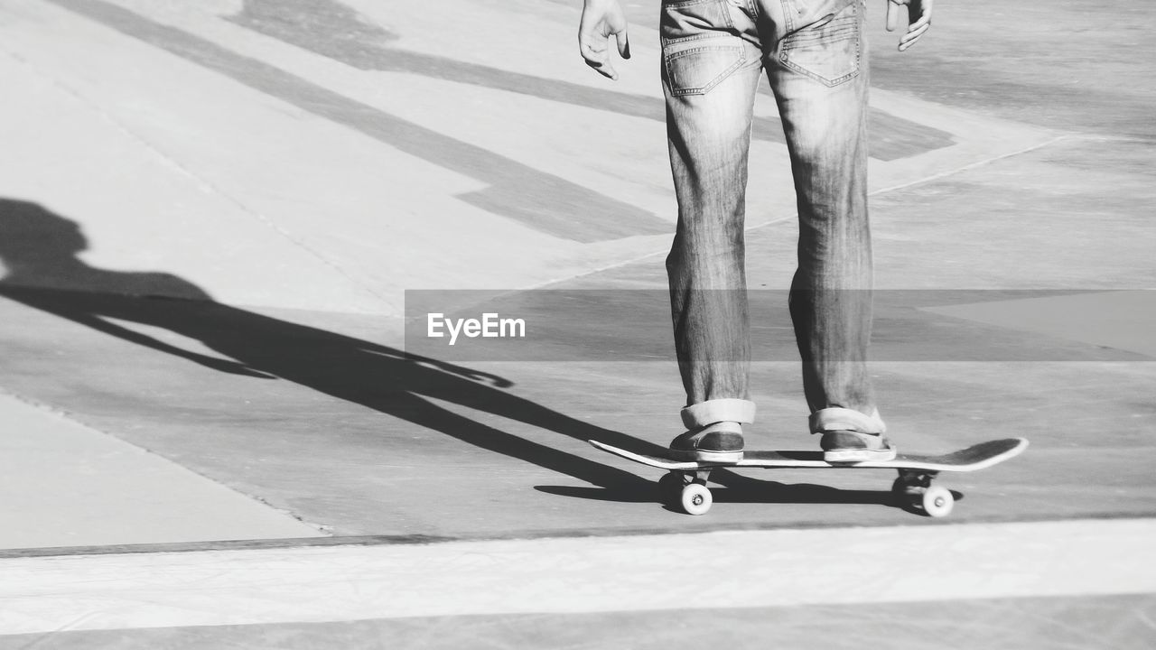 Low section of man standing on skateboard