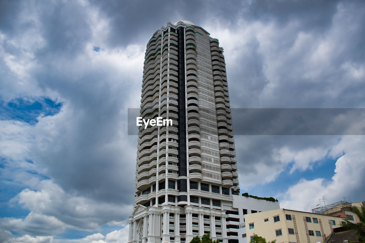 Low angle view of buildings against cloudy sky